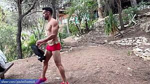 Un bărbat musculos își arată fitness-ul făcând genuflexiuni goale în aer liber
